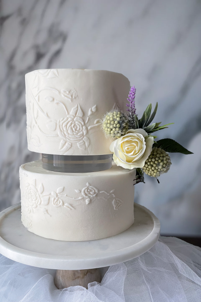 Fondant covered wedding cake with stencil appliqué and simple flower arrangement. Modern Weeding Cake